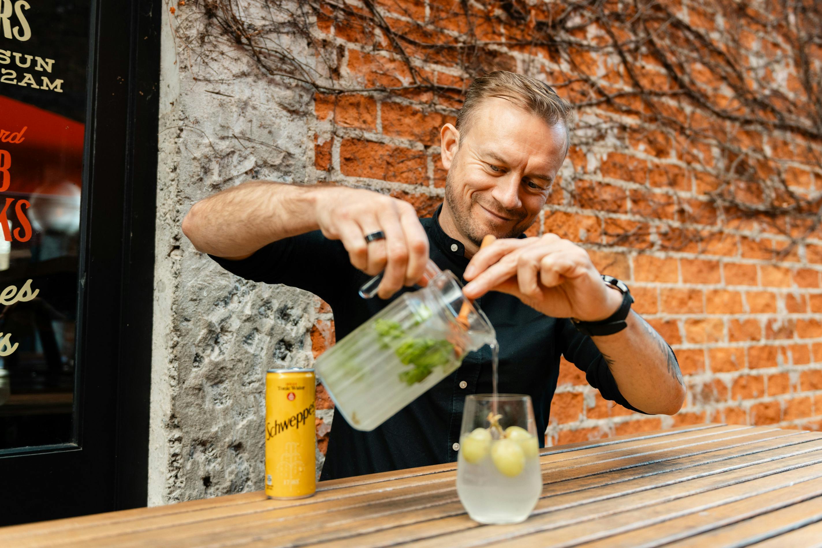 JC, creative director at Bedford Soda & Liquor pours the Sauvi Spritz cocktail into a glass